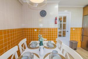 a dining room with a table and a clock on the wall at Etxea iradi in Elejalde +12 photos