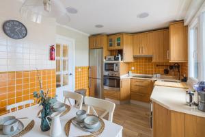 a kitchen with wooden cabinets and a table with chairs at Etxea iradi in Elejalde