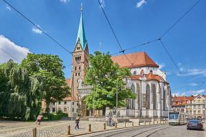 an old church with a steeple on a city street at Chic 2-room apartment in the historic cathedral district in Augsburg +6 photos
