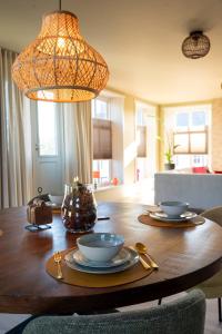 a wooden table with bowls and plates on top of it at Gastenverblijf Hunsingo in Winsum