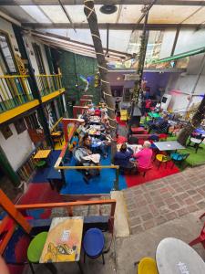um grupo de pessoas sentadas em uma sala de jogos em Hostal Gastro Bar Casa Colibrí em Bogotá