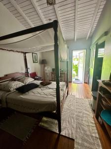 a bedroom with a large bed with a canopy at Villa Saphir B & B in Sainte-Anne +33 photos