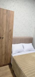een slaapkamer met een bed en een houten kast bij Apartment TunHomeDom Vagharshapat Armenia in Vagharshapat