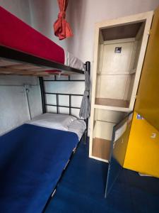 um pequeno quarto com dois beliches e uma porta em Hostal Gastro Bar Casa Colibrí em Bogotá