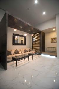 een woonkamer met een bank en een spiegel bij Cadillac Hotel in Islamabad +3 foto's