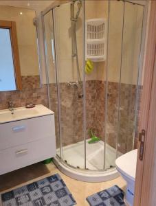 a bathroom with a shower with a toilet and a sink at Residence kettani in Bouznika