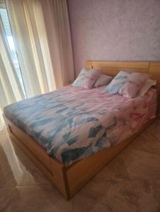 a bedroom with a bed with a wooden frame and a window at Residence kettani in Bouznika