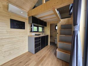 a small kitchen in a tiny house with wooden walls at In the Wild Volcano Sea Side  +19 photos