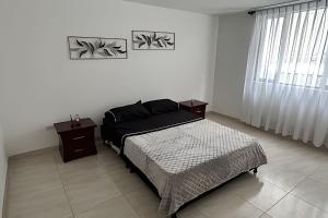 a bedroom with a bed and a window at Espacioso y Elegante en Milán in Manizales