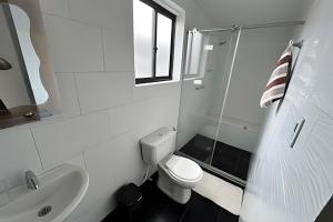 a white bathroom with a toilet and a sink at Espacioso y Elegante en Milán in Manizales