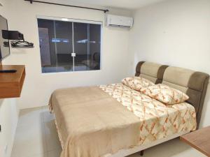 ein Schlafzimmer mit einem Bett in einem Zimmer mit einem Fenster in der Unterkunft House in Downtown East Beach with Air Conditioning in Pontal do Paraná