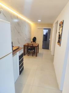 eine Küche und ein Esszimmer mit einem Tisch und einer Theke in der Unterkunft House in Downtown East Beach with Air Conditioning in Pontal do Paraná + 1 Foto