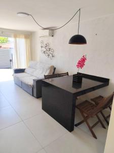 ein Wohnzimmer mit Tisch und Couch in der Unterkunft House in Downtown East Beach with Air Conditioning in Pontal do Paraná