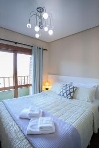 a bedroom with a large bed with towels on it at Casa Petri Gramado in Gramado