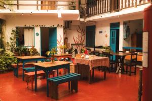 an empty restaurant with tables and chairs and plants at Maré Mansa Pousada e Hostel in Itacaré