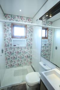 a bathroom with a shower and a toilet and a sink at Casa Petri Gramado in Gramado +19 photos