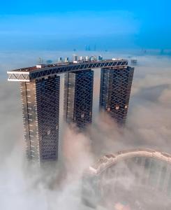 a view of the burj khalifa from above the clouds at Desert Key - Platinum Apartments in Gate Tower, Al Reem Island in Abu Dhabi