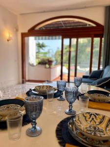 una mesa con platos y vasos encima en Casa Claudia - Positano Center 5 minutes to beach, en Positano