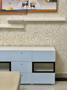 a white dresser against a wall with a pattern at Duplex tx4 in Bissau