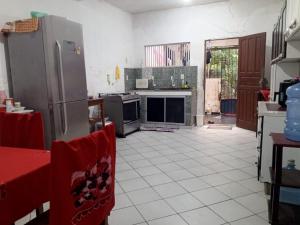 a kitchen with a refrigerator and a tile floor at Quarto para solteiro perto do aeroporto e parques in Belém