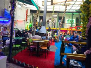 a group of people sitting at tables in a restaurant at Hostal Gastro Bar Casa Colibrí in Bogotá