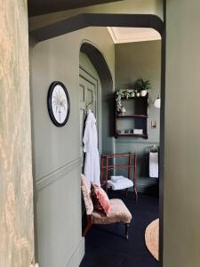 a hallway with a mirror and a chair and a clock at The Citadel in Weston