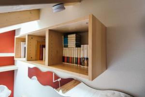 a book shelf on a wall with books on it at Chic y cozy Schwaunter in Untermeitingen