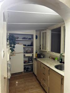 a kitchen with a white refrigerator and a sink at Cabanon pied sur mer in Mohammedia