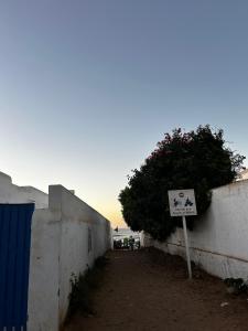 a sign on the side of a wall with a tree at Cabanon pied sur mer in Mohammedia