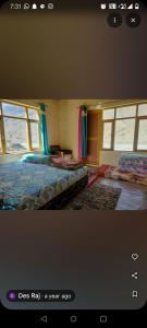 a bedroom with two beds in a room with windows at Home stay in Kaza