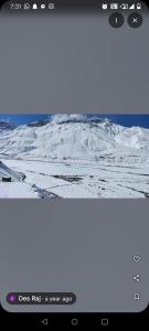 a screenshot of a photo of a snow covered mountain at Home stay in Kaza