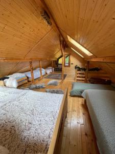 a bedroom with two beds in a wooden room at Casa Renilor in Azuga