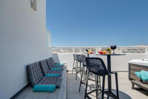 a balcony with chairs and a bar with a view at Tritoni Alta suites in Il-Gżira