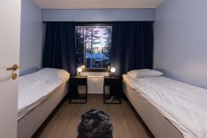 two beds in a room with a window at Teddy's Hideout in Rovaniemi