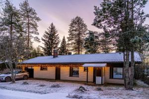 a house in the snow with a car parked in front at Teddy's Hideout in Rovaniemi