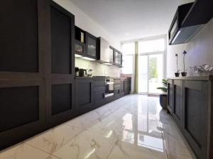 a kitchen with black cabinets and a white tile floor at Ta' Palal in Dingli
