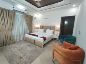 a hotel room with a bed and a chair at Margalla Residency Islamabad in Islamabad