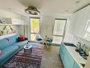 a living room with a blue couch and a kitchen at AMBER APARTMENTS - FRESH STUDIO in Morro del Jable