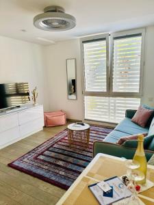 een woonkamer met een blauwe bank en een tafel bij AMBER APARTMENTS - PINK STUDIO in Morro del Jable