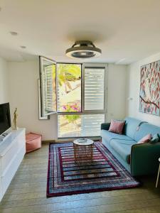 een woonkamer met een blauwe bank en een tafel bij AMBER APARTMENTS - PINK STUDIO in Morro del Jable