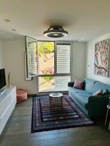 een woonkamer met een blauwe bank en een tafel bij AMBER APARTMENTS - PINK STUDIO in Morro del Jable