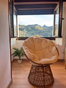 a chair in a room with a large window at Casa Criseva II in Avín
