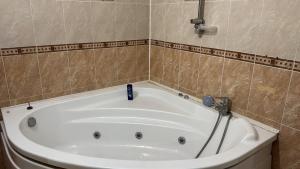 a bath tub in a tiled bathroom with at Актобе ажары in Aktobe