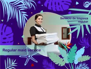 Una mujer sostiene una pila de toallas. en Nice condo with fresh pool, en Punta Cana 3 fotos más