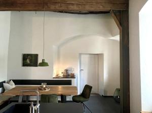 a dining room with a wooden table and a chair at Charmantes Chateau Lichter - Burghaus in Ließem
