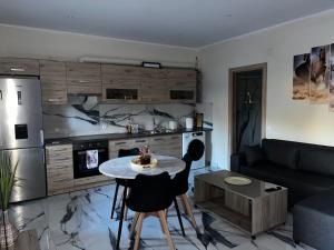 a living room with a table and a kitchen at Villa Aretousa in Ágios Prokópios