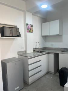 a kitchen with white cabinets and a sink at Departamento en malecon acogedor in San Bartolo