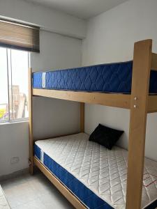 two bunk beds in a room with a window at Departamento en malecon acogedor in San Bartolo