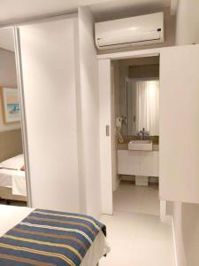 a bedroom with a bed and a bathroom with a sink at Apartamento Vista Mar Santos in Santos