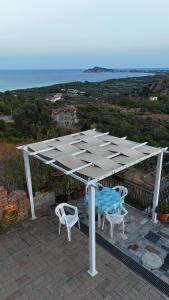 een wit paviljoen met twee stoelen en een tafel bij Appartamento Mariolu 2 in Santa Maria Navarrese